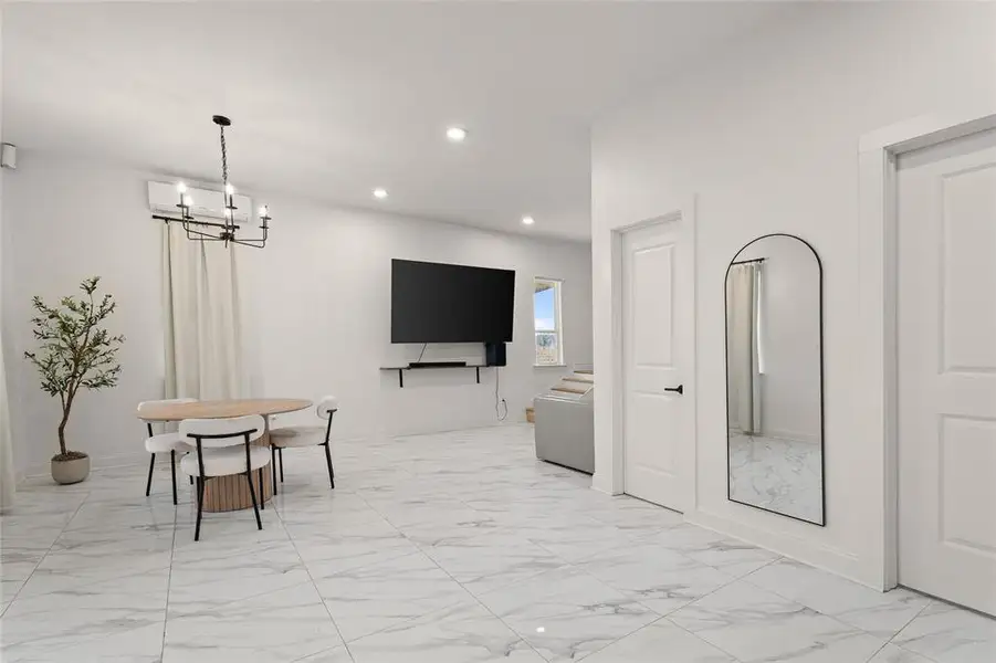 Dining space featuring light marble finish floors, recessed lighting, and a chandelier
