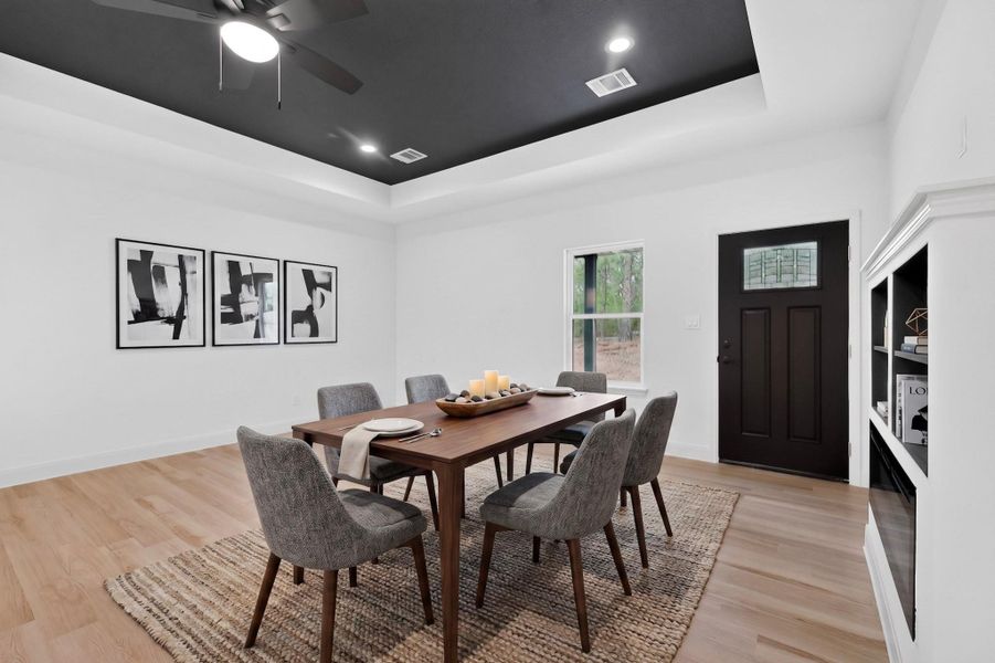 Dining area featuring a tray ceiling with a dark finish, recessed lighting, and a ceiling fan Dining area featuring a tray ceiling with a dark finish, recessed lighting, and a ceiling fan