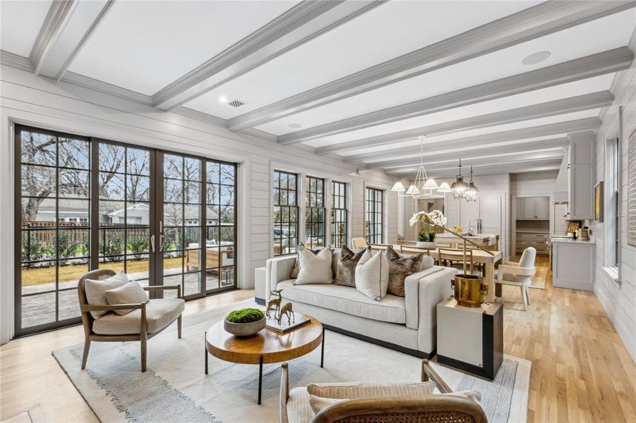 Sunroom with beam ceiling, visible vents, a notable chandelier, and french doors