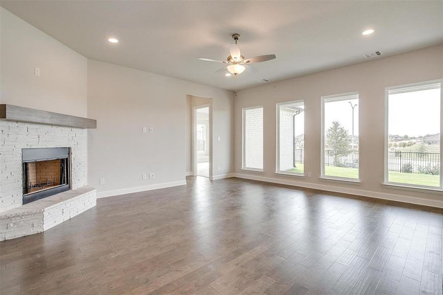 Unfurnished living room with ceiling fan and dark hardwood / wood-style flooring