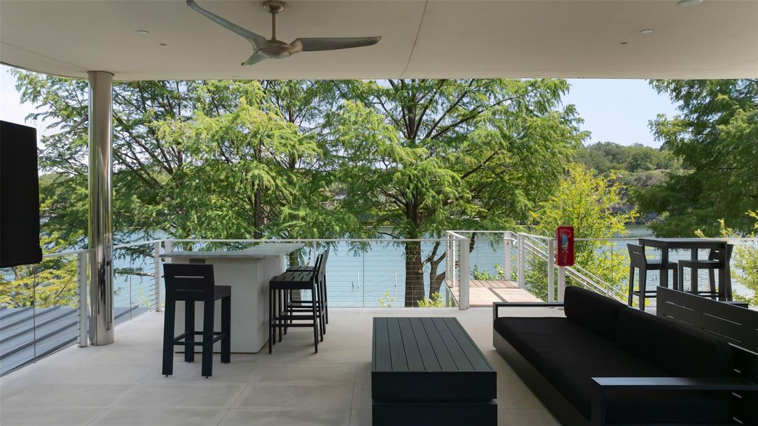 View of patio / terrace with an outdoor lounge area with bar and ceiling fan