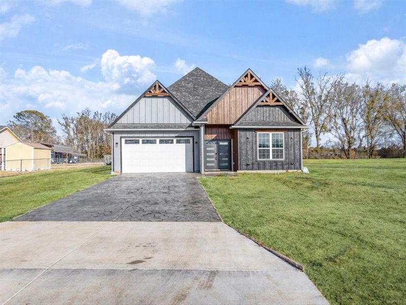 Craftsman inspired home with a front lawn, driveway, a garage, and board and batten siding Craftsman inspired home with a front lawn, driveway, a garage, and board and batten siding