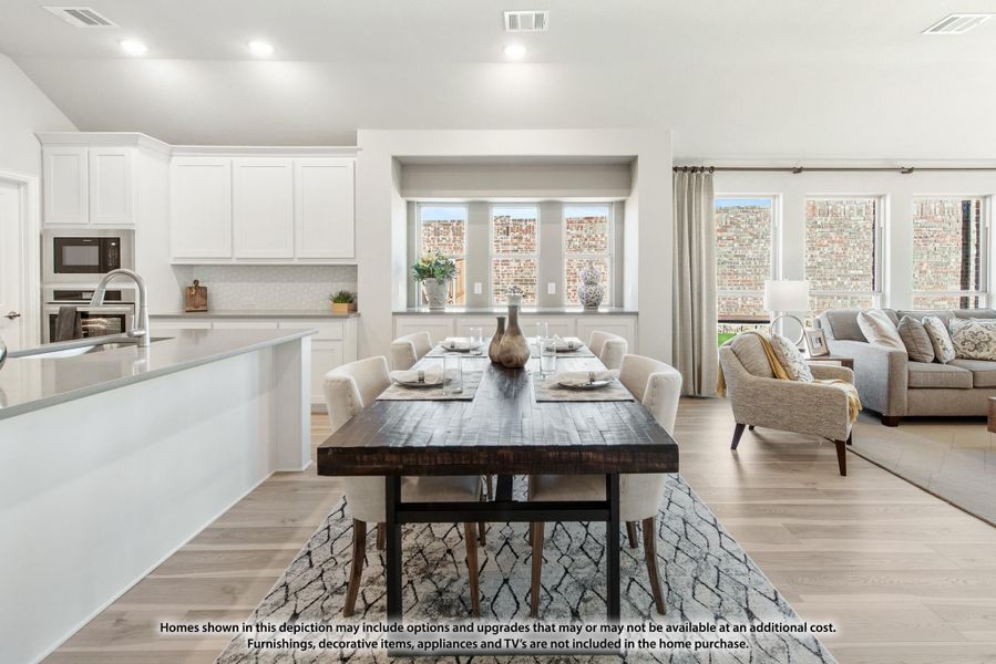 Open-plan dining area with dark wood table, white kitchen cabinets, and living room visible beyond Open-plan dining area with dark wood table, white kitchen cabinets, and living room visible beyond