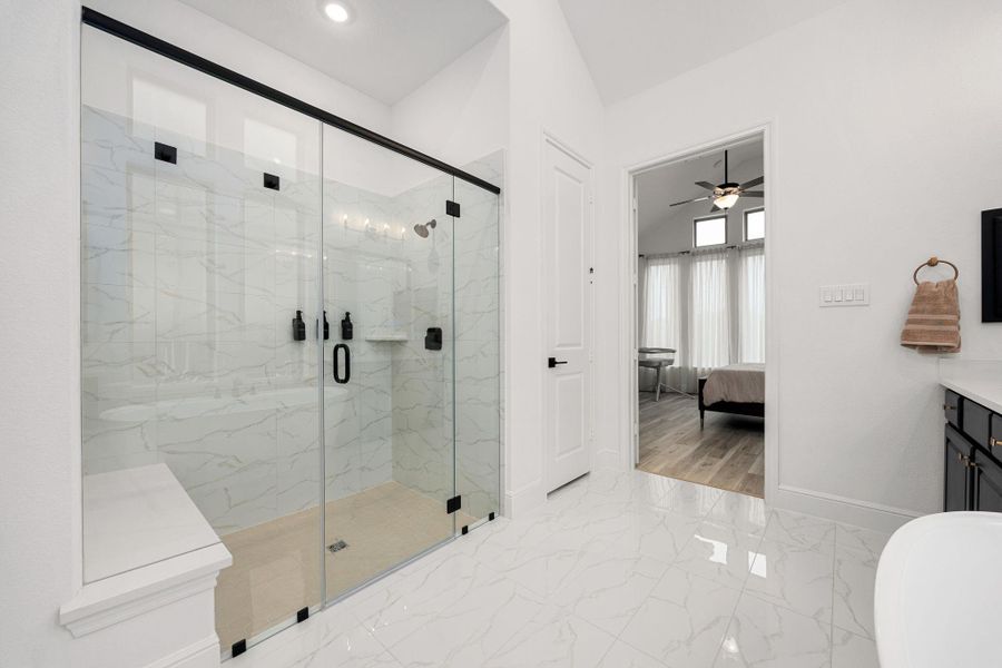 The primary bathroom features a generous walk-in shower with glass enclosure and modern finishes.
