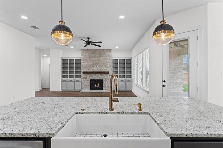 The kitchen features a farmhouse sink, gold-toned faucet, and granite countertops