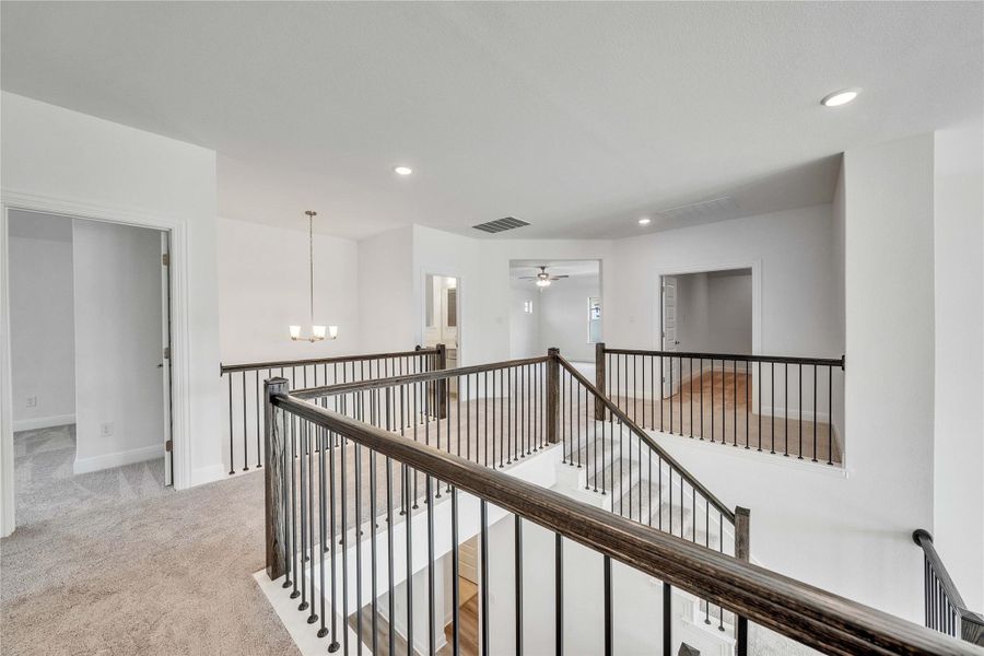 Hall featuring an upstairs landing, a chandelier, light colored carpet, and recessed lighting Hall featuring an upstairs landing, a chandelier, light colored carpet, and recessed lighting