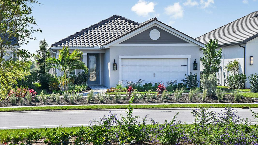Front exterior of a new home in SkySail Real Estate and Homes for Sale in Naples, FL - Neal Communities, Naples, FL, highlighting curb appeal (Image 2).