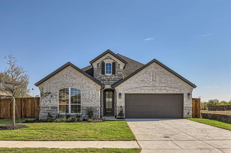 French country style house featuring a front yard and a garage