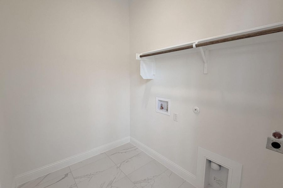 Laundry area featuring gas dryer hookup, hookup for a washing machine, light marble finish floors, and electric dryer hookup