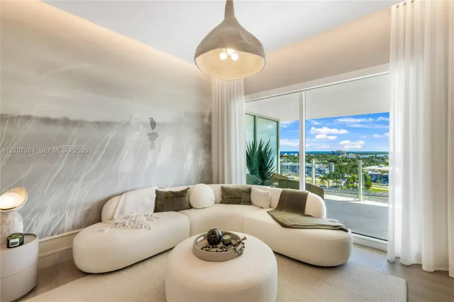 Floor-to-ceiling sliding glass door, spacious balcony with glass railing, large custom pendant lighting, recessed cove lighting, and neutral-toned wall mural Floor-to-ceiling sliding glass door, spacious balcony with glass railing, large custom pendant lighting, recessed cove lighting, and neutral-toned wall mural