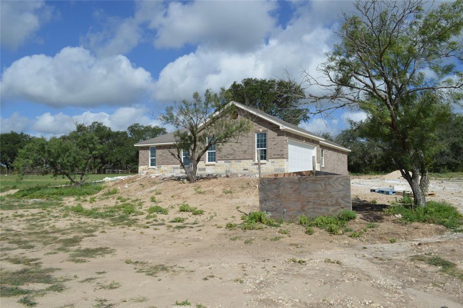 View of property exterior featuring stone siding and an attached garage View of property exterior featuring stone siding and an attached garage