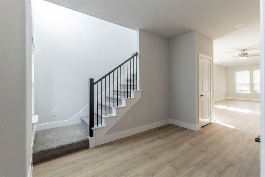 Stairs featuring wood finished floors and a ceiling fan