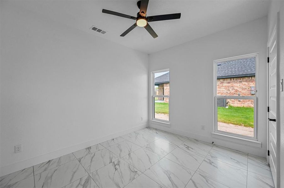 Tiled empty room with ceiling fan