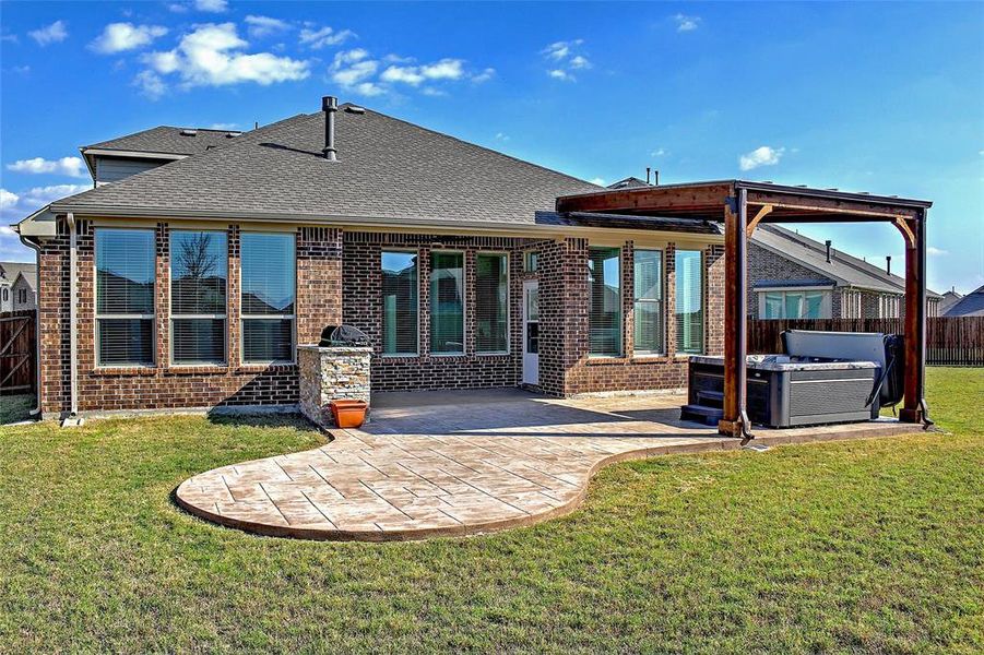 extended stamped concrete patio with a built in grill and covered hot tub.