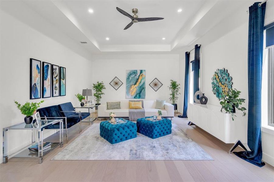 Living area with ceiling fan, wood finished floors, a tray ceiling, and recessed lighting