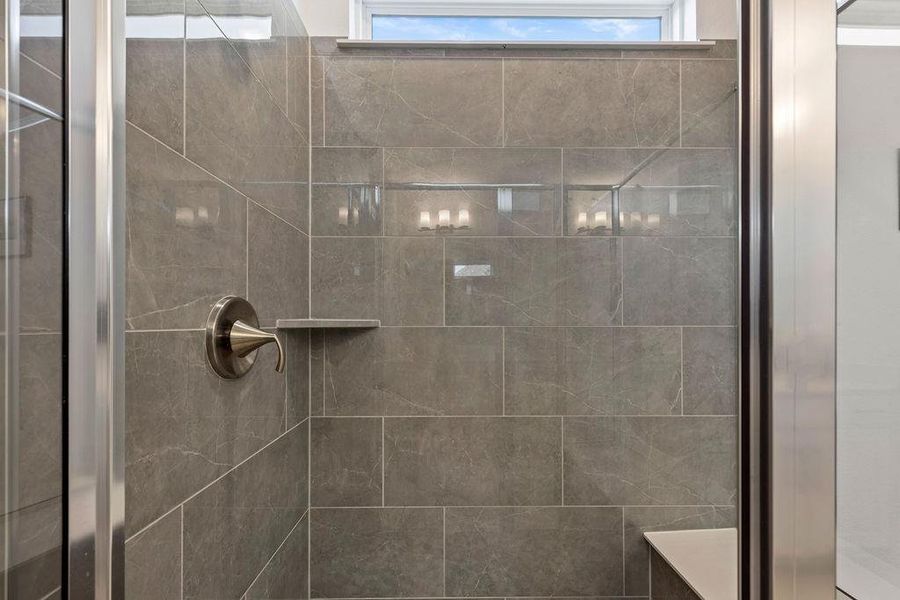 Walk-in primary shower with seat.