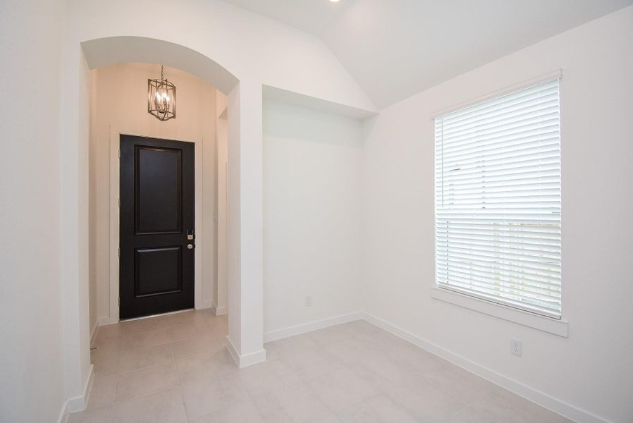 This is the bright, snow white front entry from the inside. Note the recessed wall niche, neutral floor tiling, and one of many windows, bathing this area in pure natural light.