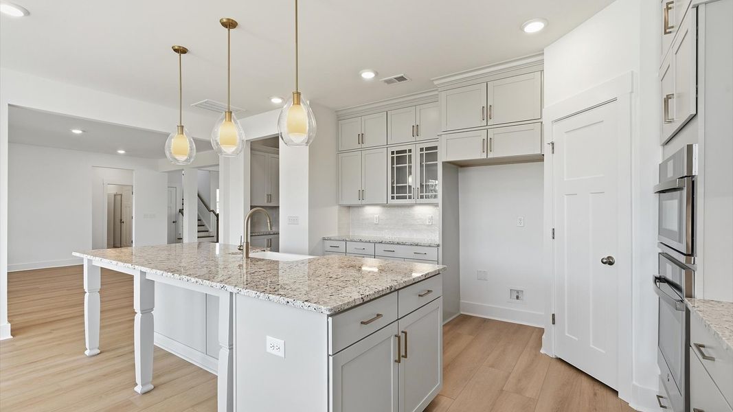 Exceptional kitchen featuring a spacious island, eye-catching pendant lights, and modern finishes at Pinebrook