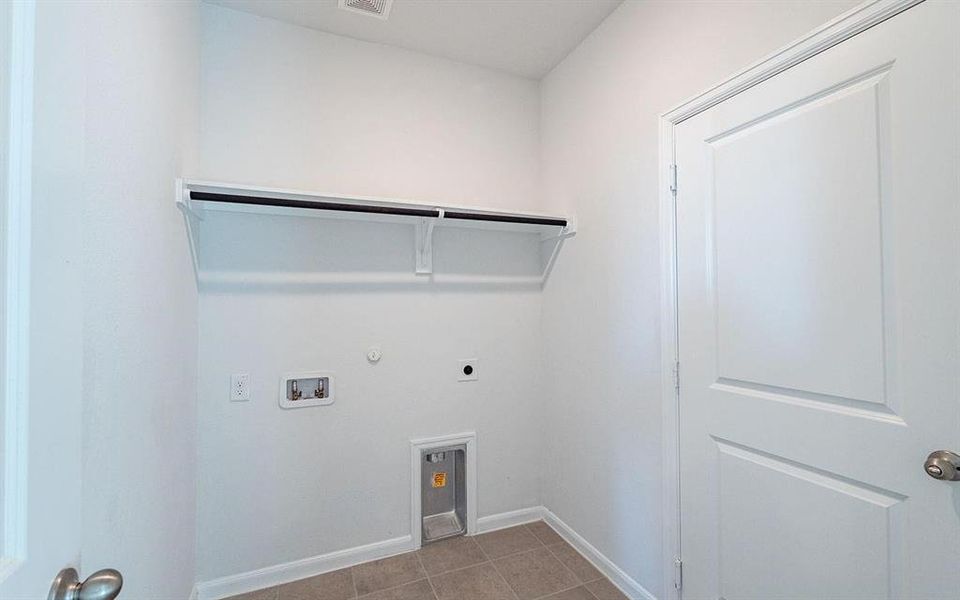 Laundry room featuring hookup for an electric dryer, hookup for a gas dryer, hookup for a washing machine, and light tile patterned floors