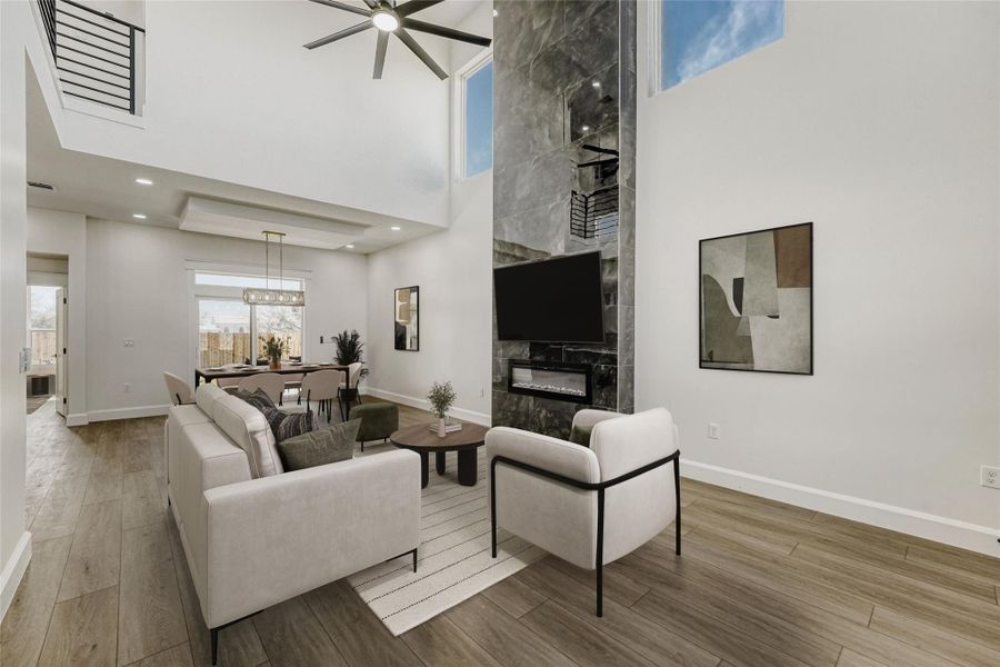 Inside you will find a breathtaking open floor plan under soaring ceilings with a showstopper designer fireplace. (virtually staged photo)