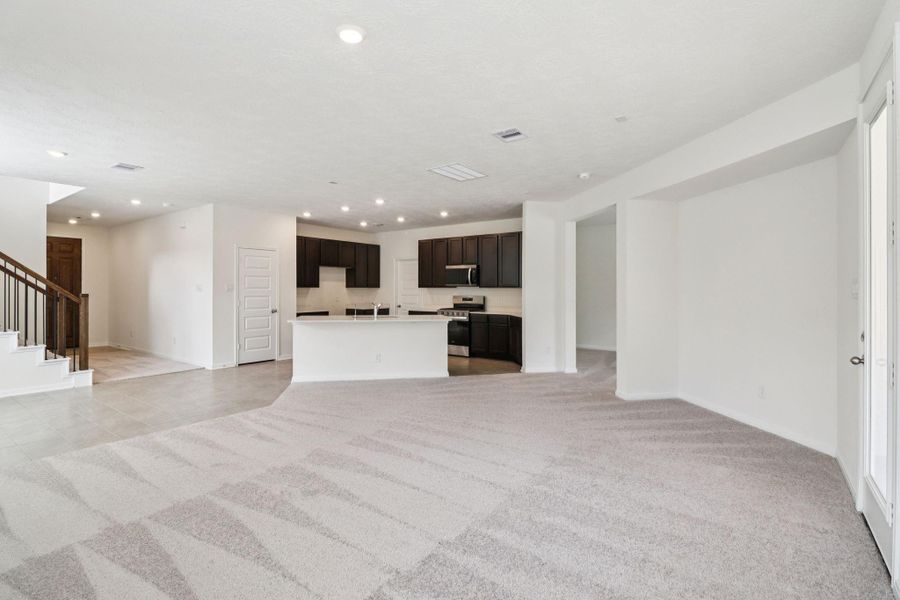 Thoughtfully designed with an open layout, the family room offers clear sightlines to the entryway, ensuring you remain effortlessly connected to guests and family the moment they step through the front door.