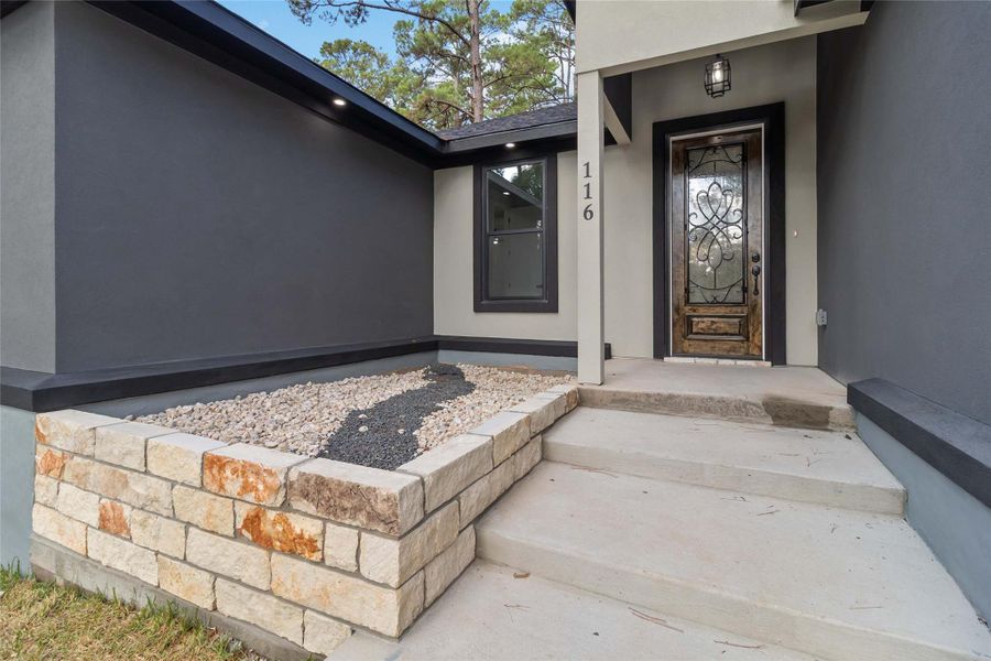 Doorway to property featuring stucco siding