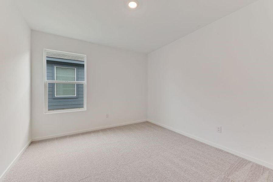 Empty room with light colored carpet and baseboards