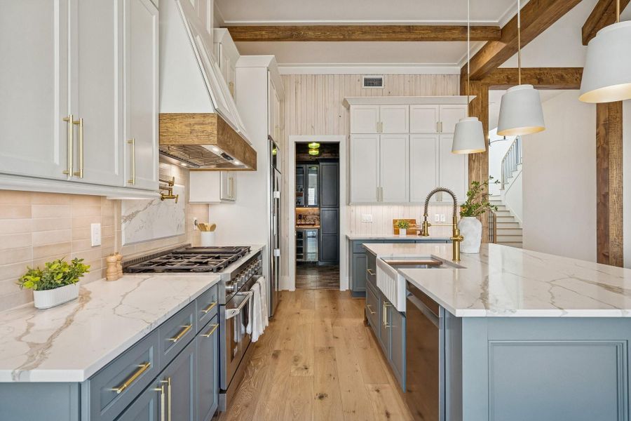 A 48 in gas range with a commercial grade vent hood, and 42in built in fridge set the tone for the appliances. Quartz counters, pot filler, shoji washed wood accents and pendant lighting bring the bling.
