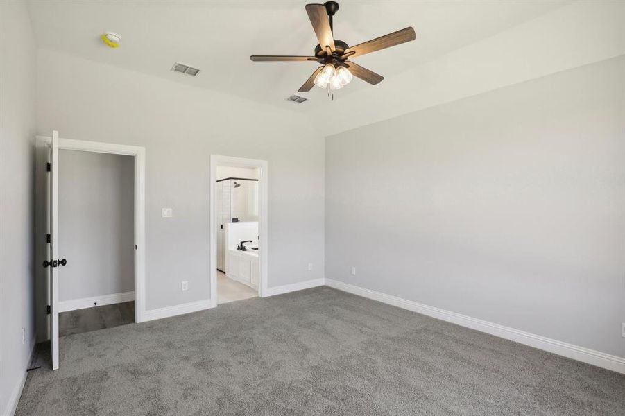 Unfurnished bedroom with carpet flooring, connected bathroom, and ceiling fan