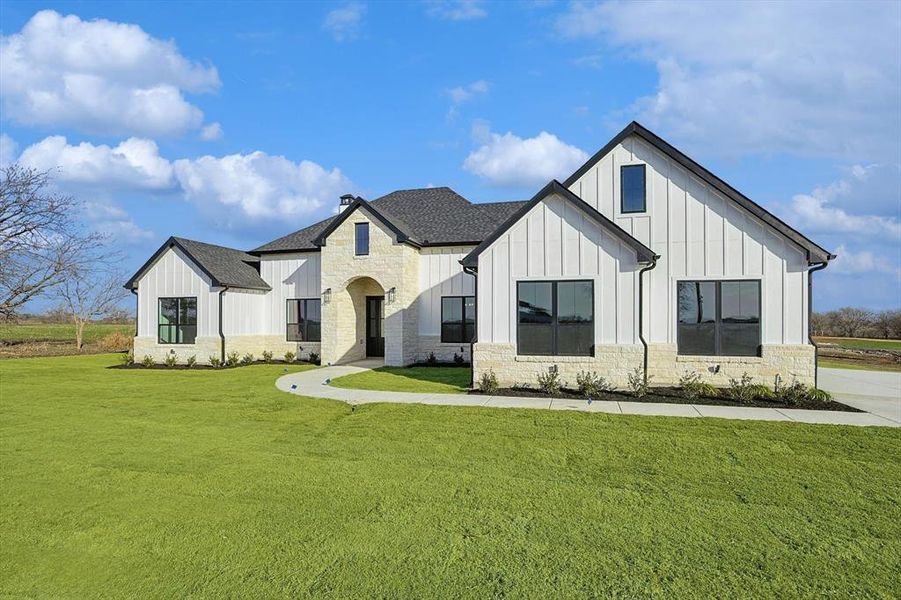 Modern farmhouse style home with a front lawn