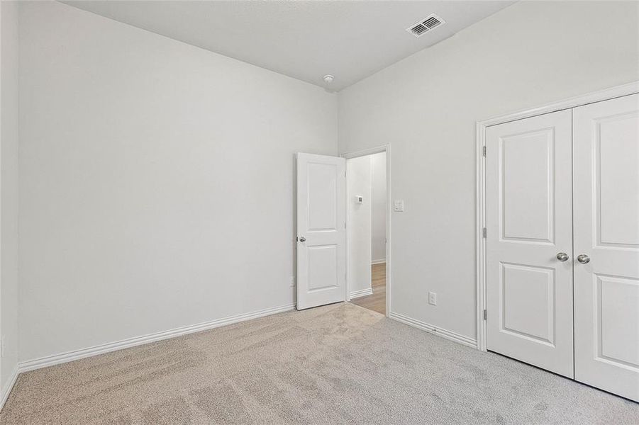 Unfurnished bedroom with a closet and light colored carpet