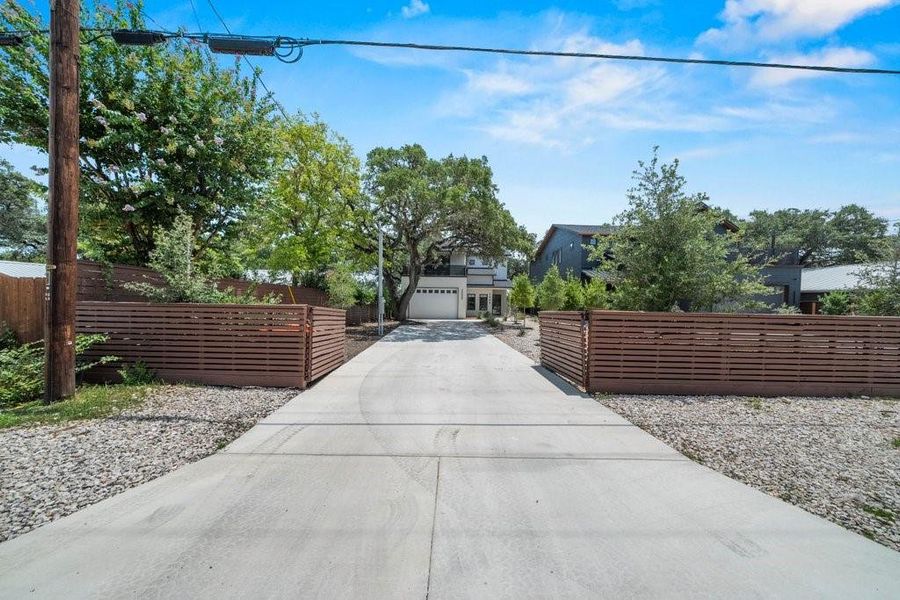 A long gated driveway welcomes you into this private one-acre compound, offering generous parking, mature shade trees, and an impressive sense of arrival. A long gated driveway welcomes you into this private one-acre compound, offering generous parking, mature shade trees, and an impressive sense of arrival.