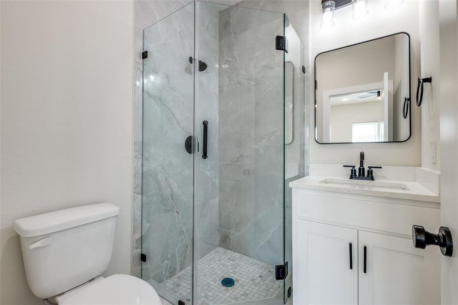 Full bathroom featuring vanity and a marble finish shower