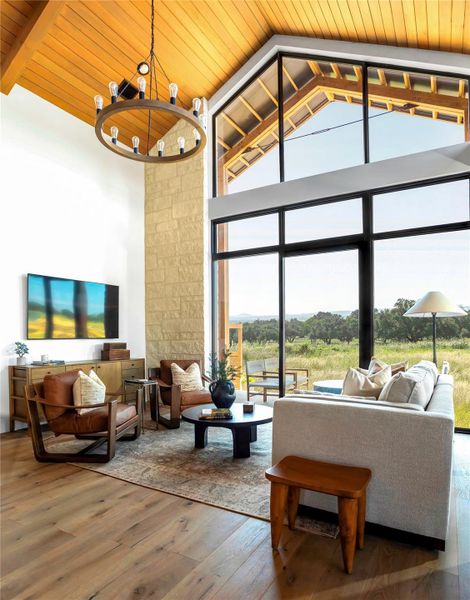 Dramatic floor-to-ceiling windows and vaulted wood ceilings create a bright, inviting living area with seamless indoor-outdoor connection.