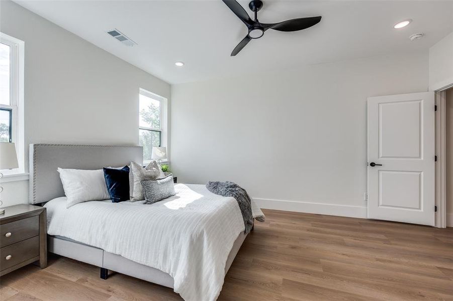 Bedroom with light wood finished floors, ceiling fan, and recessed lighting Bedroom with light wood finished floors, ceiling fan, and recessed lighting