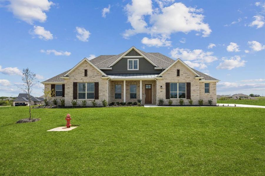 Craftsman inspired home with a standing seam roof, brick siding, a metal roof, and a front lawn