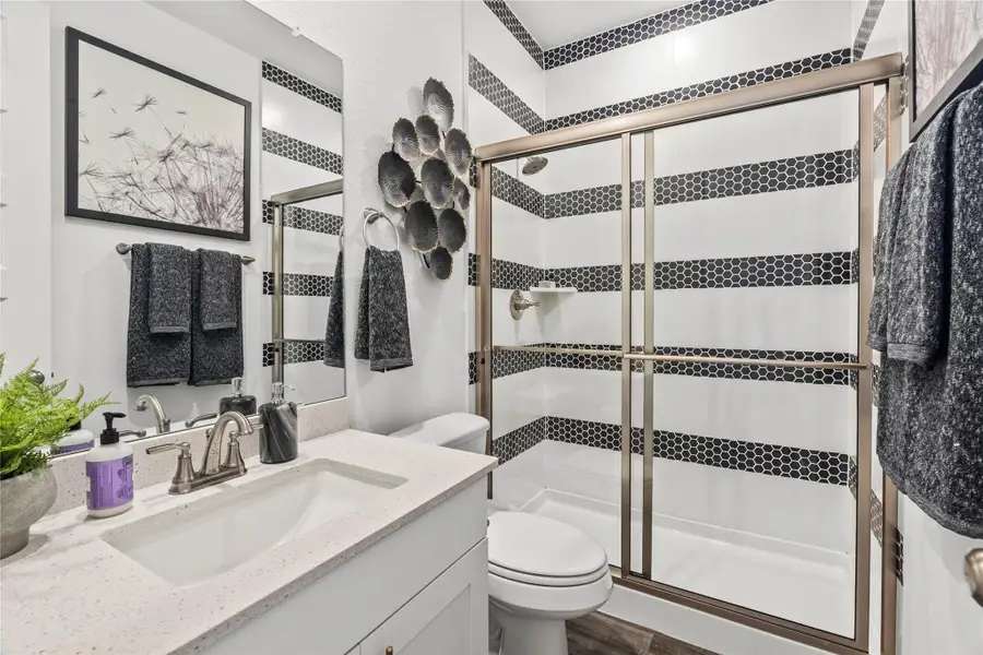 Bathroom featuring vanity, a shower stall, and wood finished floors