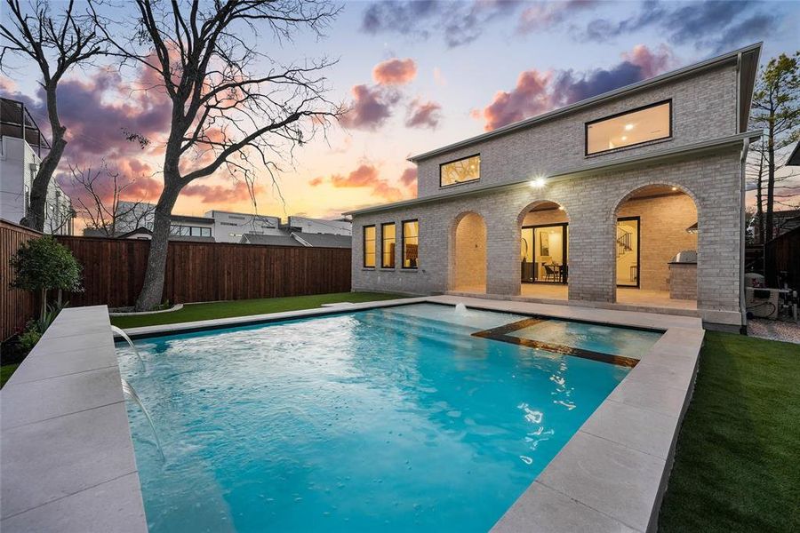 Back of house at dusk with a patio, a fenced backyard, and brick siding Back of house at dusk with a patio, a fenced backyard, and brick siding