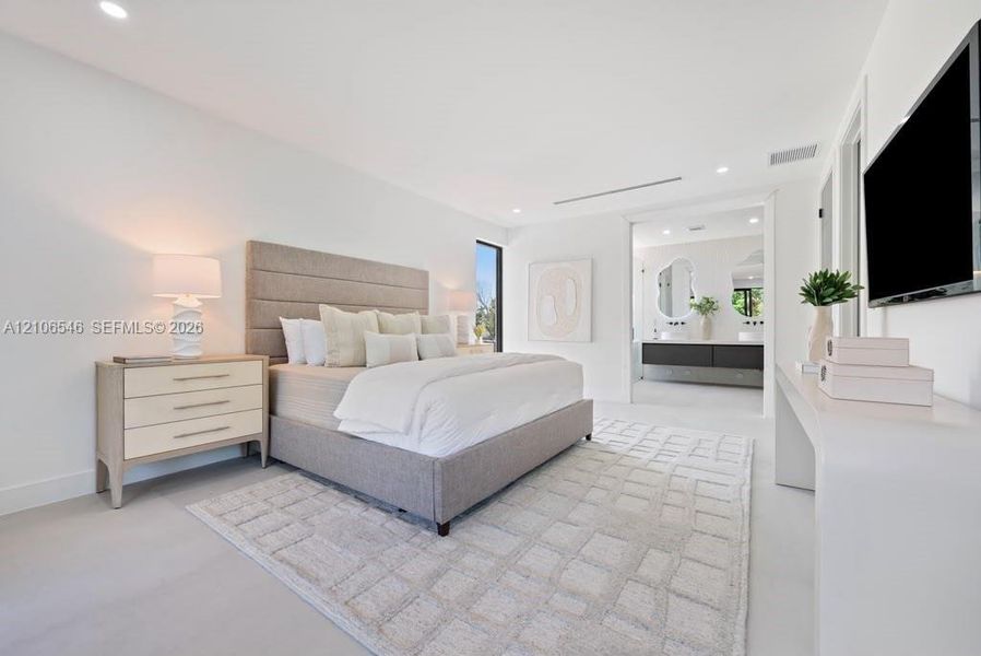 Spacious room featuring neutral tone-on-tone walls, smooth-finish flooring, recessed lighting, and a long built-in console table