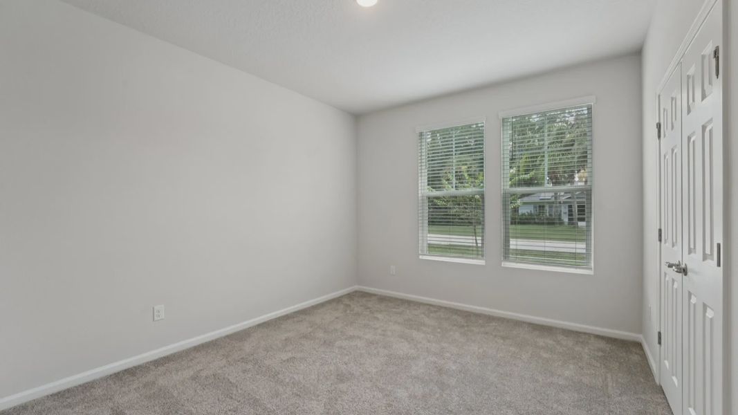 Plush carpet and large windows enhance this Palm Coast bedroom, offering serene comfort and style.