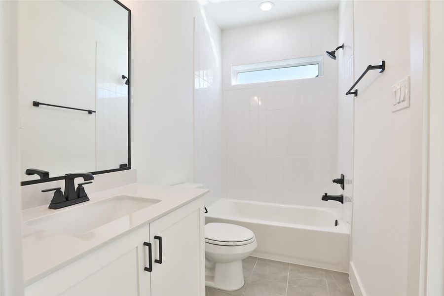 The third full bathroom features a shower/tub combination, with sleek black accents that enhance its modern design.
