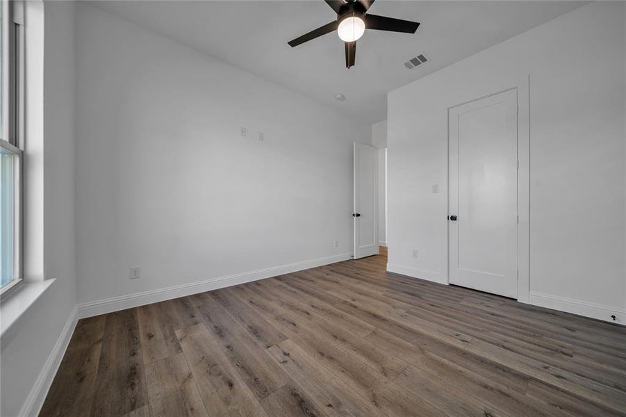 Unfurnished bedroom with wood finished floors and a ceiling fan
