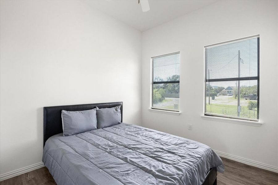 Bedroom with dark wood-type flooring and ceiling fan