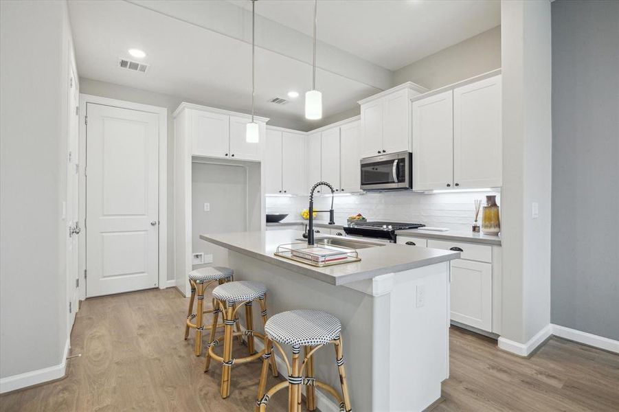 Kitchen features designerbacksplash, walk in pantry,stainless steel appliances andquartz countertops.