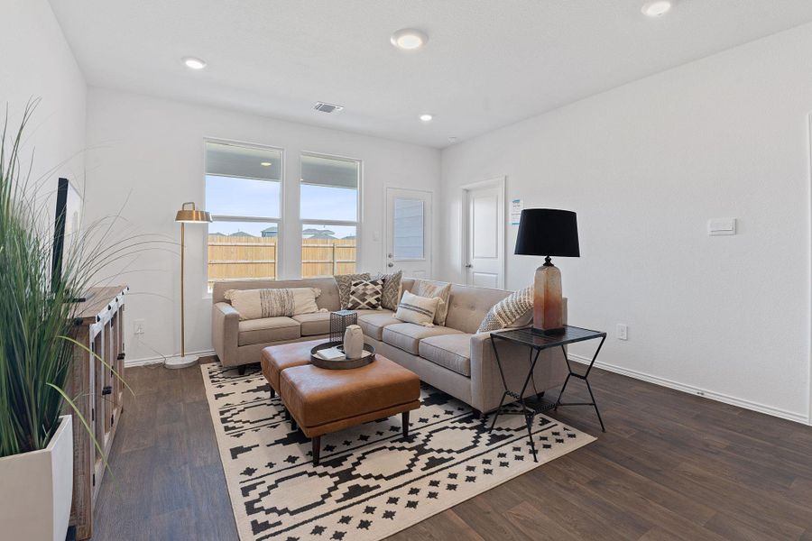 Living room with dark wood-style floors, baseboards, visible vents, and recessed lighting