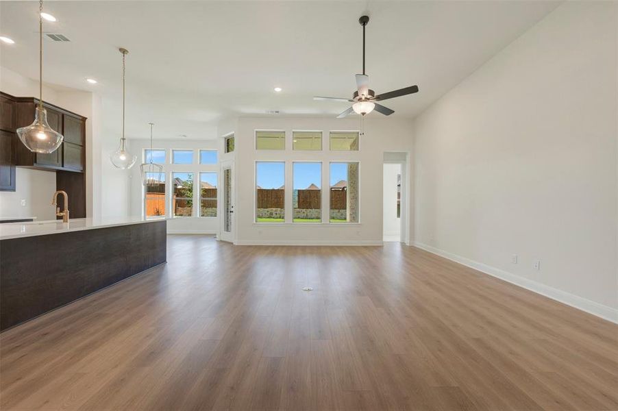 Spacious open-concept interior featuring light wood-finish flooring and high vaulted ceilings Spacious open-concept interior featuring light wood-finish flooring and high vaulted ceilings