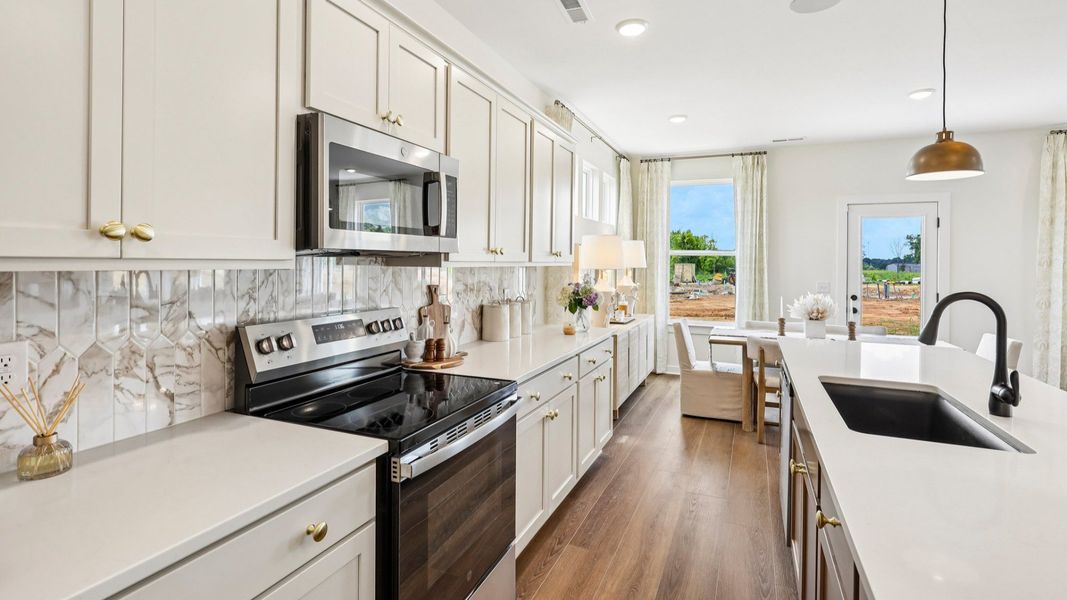 Kitchen with tile backsplash, pendant lighting, and quartz countertops
