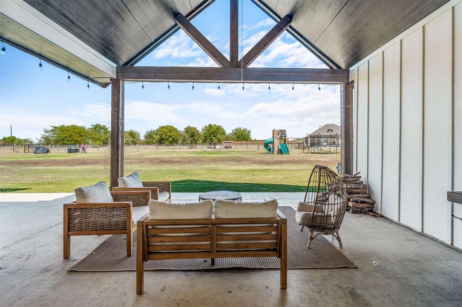 View of patio with a playground and an outdoor hangout area