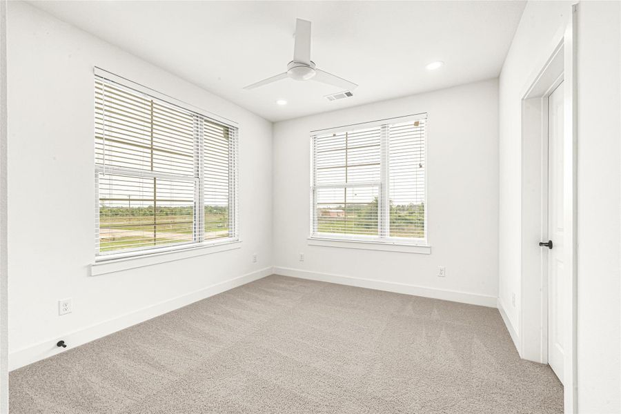 Secondary Bedroom 1 offers a bright, neutral palette, and soft carpeting, making it an ideal space for a cozy guest room, bright nursery, or a home office. Access to a Jack and Jill bathroom shared with secondary bedroom 2.