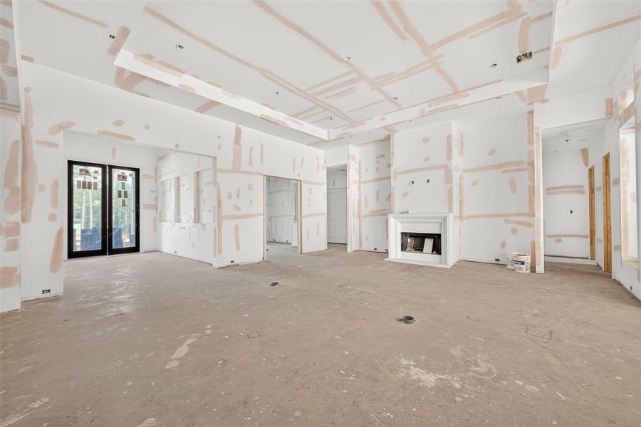Family room will feature coffered deco beams on the ceiling, gas stone cased fireplace, and floor outlets